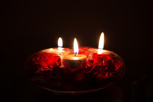 red candles in a candlestick on a black background, close-up