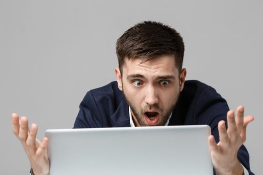 Business Concept - Portrait handsome stressful business man in suit shock looking at work in laptop. White Background.