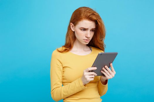 Close up Portrait young beautiful attractive tender ginger redhair girl happy smiling on digital table with wining something. Blue Pastel Background. Copy space.