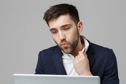 Business Concept - Portrait handsome stressful business man in suit shock looking at work in laptop. White Background.