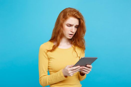 Close up Portrait young beautiful attractive tender ginger redhair girl happy smiling on digital table with wining something. Blue Pastel Background. Copy space.