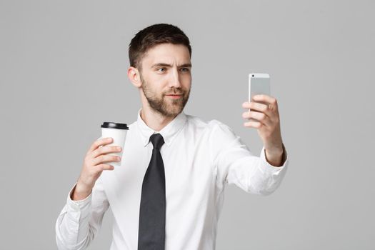 Lifestyle and Business Concept - Portrait of a handsome businessman enjoy taking a selfie with take away cup of coffee. Isolated White background. Copy Space.