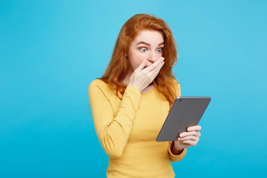 People and Technology Concept - Close up Portrait young beautiful attractive redhair girl happy smiling on digital table with wining something. Blue Pastel Background. Copy space.