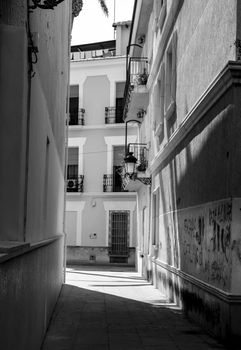 Novelda, Alicante, Spain- September 18, 2021: Beautiful narrow street of Novelda village in Alicante province. Monochrome picture.