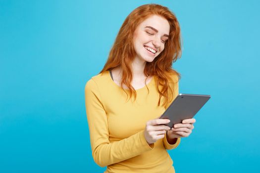 People and Technology Concept - Close up Portrait young beautiful attractive redhair girl happy smiling on digital table with wining something. Blue Pastel Background. Copy space.