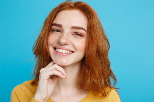 Close up Portrait young beautiful attractive redhair girl smiling looking at camera. Blue Pastel Background.