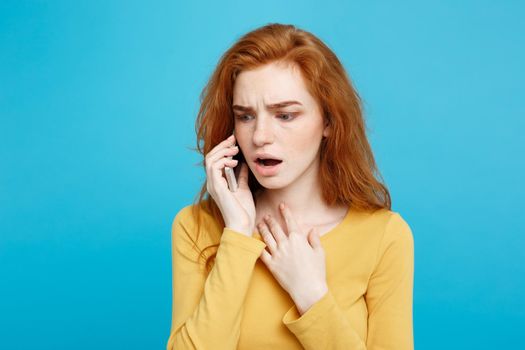 Portrait of a surprised confused woman in yellow casual calling mobile phone isolated over blue background