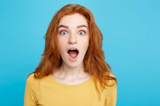 Close up Portrait young beautiful attractive redhair girl shocking with something. Blue Pastel Background. Copy space.