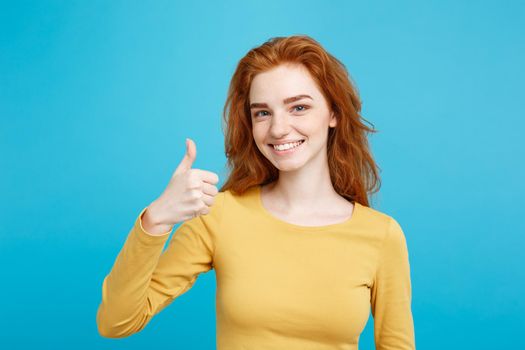 Portrait of young stylish freckled girl laughing with showing thumps up at camera. Copy space.