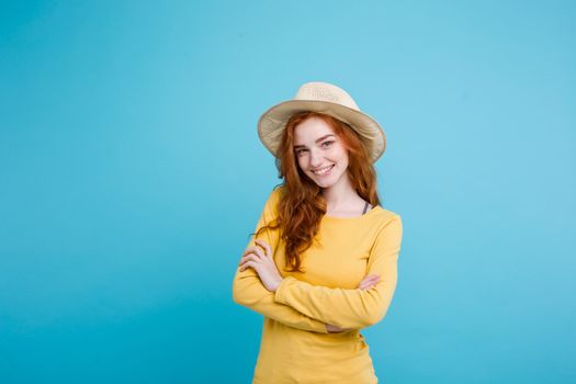 Travel concept - Close up Portrait young beautiful attractive redhair girl wtih trendy hat and sunglass smiling. Blue Pastel Background. Copy space.