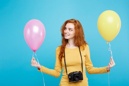 Lifestyle and Party concept - Close up Portrait young beautiful attractive ginger red hair girl with colorful balloon and vintage camera. Blue Pastel Background. Copy space.