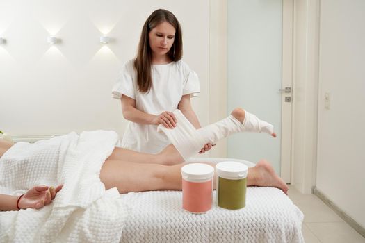 Anti-cellulite wraps procedure for legs in a spa center. Clear skin and perfect body concept