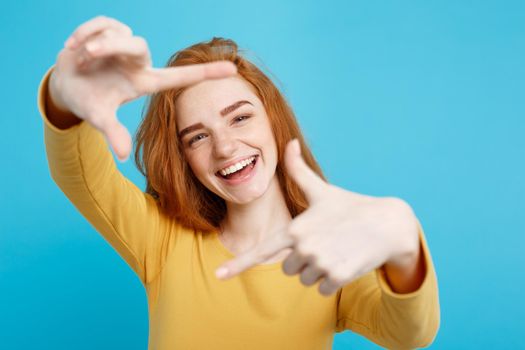 Close up Portrait young beautiful attractive redhair girl smiling looking at camera. Blue Pastel Background.