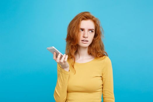 Lifestyle concept - Portrait of a shocked surprised girl in yellow dress talking on mobile phone. Isolated on Blue Pastel Background. Copy space.