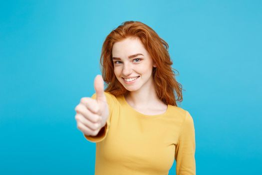 Portrait of young stylish freckled girl laughing with showing thumps up at camera. Copy space.