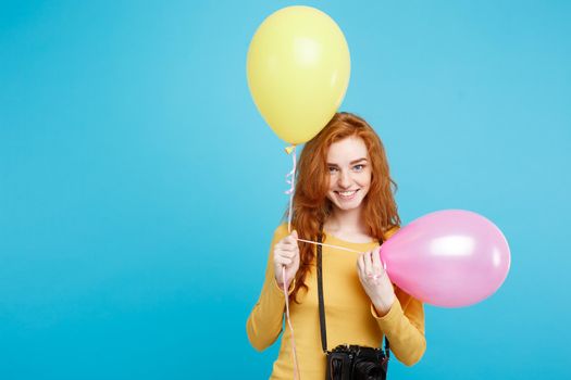 Lifestyle and Party concept - Close up Portrait young beautiful attractive ginger red hair girl with colorful balloon and vintage camera. Blue Pastel Background. Copy space.