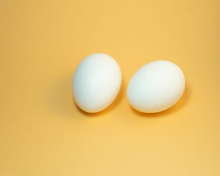 two eggs on a yellow background. Two  chicken eggs
