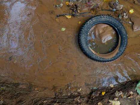 Tires in the sand at the bottom of the stream. Bad ecology