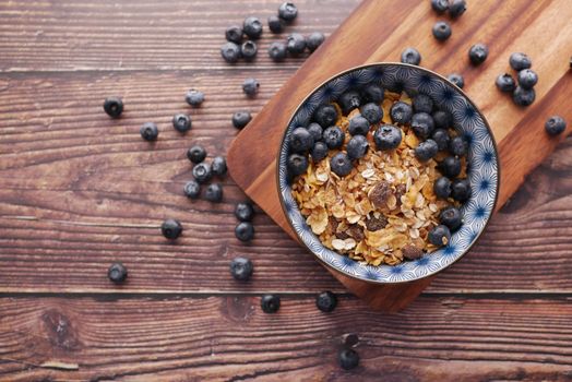 cereal breakfast and blue berry in bowl on table .