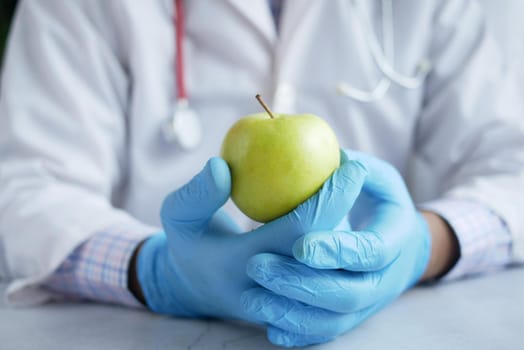 doctor's hand holding green apple while sited ,