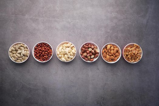 walnut , cashew nut and almond in a container on table .