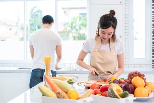 Asian lovers or couple cooking and slicing vegetable in kitchen room. Holiday and Honeymoon concept. Valentine day and wedding theme