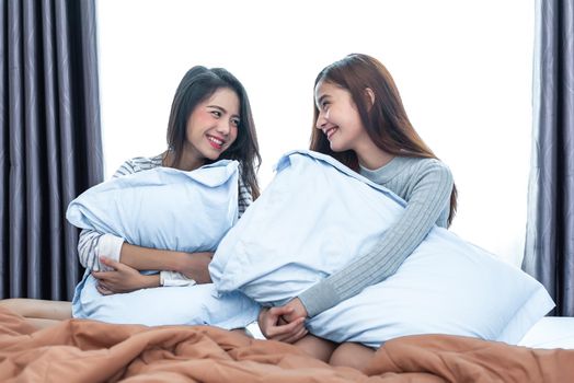 Two Asian Lesbian looking together in bedroom.Beauty concept. Happy lifestyles and home sweet home theme. Cushion pillow element and window background. LGBT pride theme.