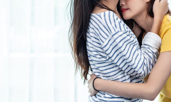 Close up of two Asian Lesbian women looking together in bedroom. Couple people and Beauty concept. Happy lifestyles and home sweet home theme. Embracing of homosexual. Love scene making of female