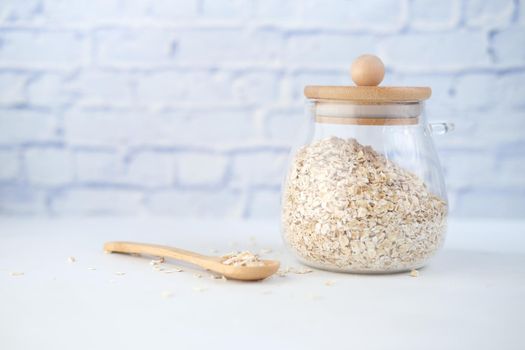 oats flakes in a jar with spoon on table .