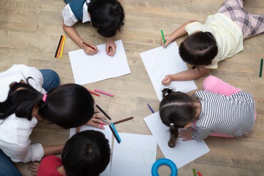 Group of preschool student and teacher drawing on paper in art class. Back to school and Education concept. People and lifestyles theme.  Room in nursery