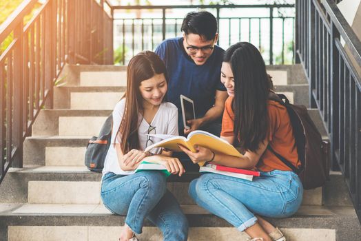 Group of Asian college student using tablet and mobile phone outside classroom. Happiness and Education learning concept. Back to school concept. Teen and people theme. Outdoors and Technology theme.