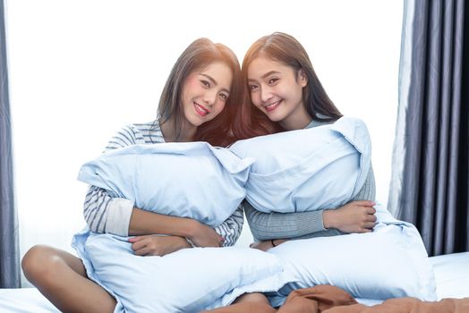 Two Asian Lesbian in bedroom. Beauty concept. Happy lifestyles and home sweet home theme. Cushion pillow element and window background.