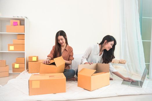 Two young Asian people startup small business entrepreneur SME distribution warehouse with parcel mail box. small  owner home office. Online marketing and product packaging and delivery service