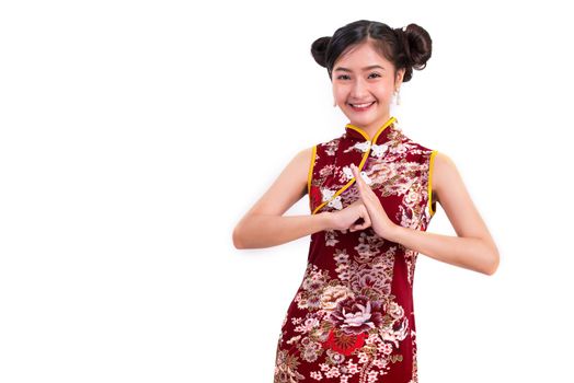 Young Asian beauty woman wearing cheongsam and blessing or greeting gesture in Chinese new year festival event on isolated white background. Holiday and Lifestyle concept. Qipao dress wearing