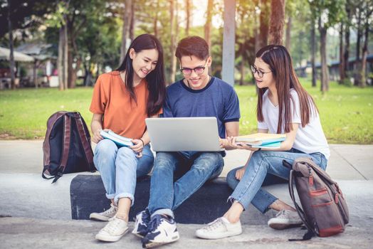 Three Asian young campus students enjoy tutoring and reading books together. Friendship and Education concept. Campus school and university theme. Happiness and funny of learning in college