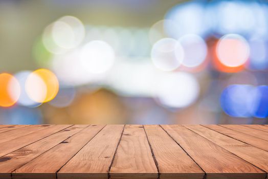 Empty wood table with colorful abstract bokeh. Wallpaper and texture concept. City light and Product stage showing theme. Presentation template