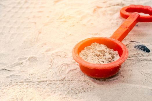 Sand in plastic spoon. Beach and Playground concept. Nature and Vacation theme.