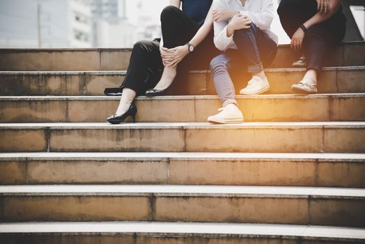 Close up lower legs of women friendship sitting and talking to each others at stair in outdoors. Relationship and Lifestyle concept. Business and Relax concept. City and Friend theme.