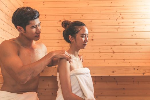 Young Asian couples or lovers have romantic relaxing in sauna room. Skin care heat treatment and body clean up and refreshing in spa with steam bath. Healthy and Honeymoon concept. Happiness together