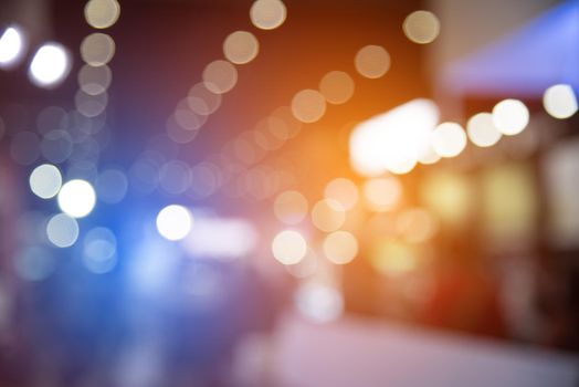 Abstract blurred of festival event with people and motor show background. Convention and Business event concept. People and lifestyle theme. Orange and Blue light tone. Defocused photo
