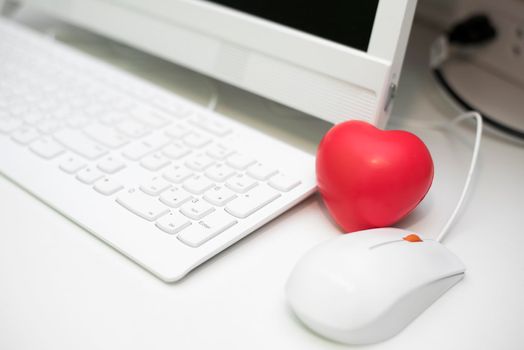 Red heart in office with computer desk set. Mini and small size of sponge heart for Muscle relaxant in hospital. Dating and Flirting concept. Valentines day and Love theme. Keyboard and mouse elements