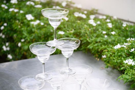 Closeup group of stacking martini wine glasses on outdoors counter bar in the garden for prepare celebration party.