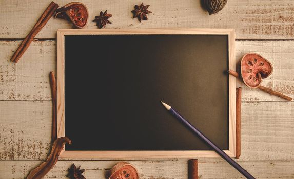 School empty wooden blackboard on wooden floor with pencil and dry leaves. Education and Nature concept. Back to school theme. Top view and flat lay