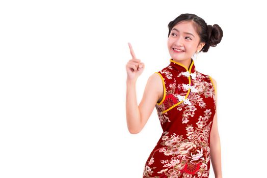 Young Asian beauty woman wearing cheongsam and pointing beside gesture in Chinese new year festival event on isolated white background. Holiday and Lifestyle concept. Qipao dress wearing