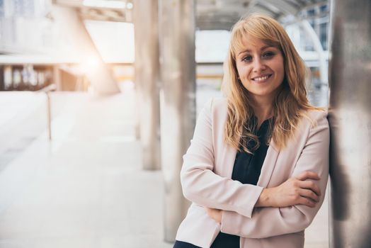 Happy beautiful smiling business woman at outside of office background. CEO manager businesswoman in formal wear suit having confidence and cheerful. People lifestyle concept. Looking at camera