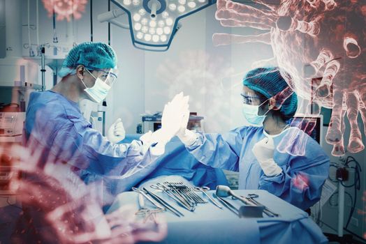 Doctors and nurse do hi five after succeeding surgery patient lung for treatment from Coronavirus infection in operation room. Healthcare and Hospital concept. Virus outbreak and illness encouragement