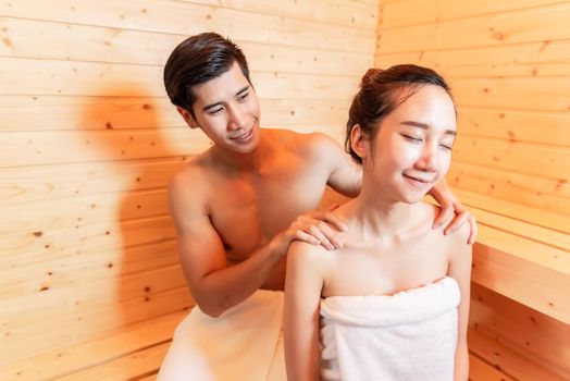 Young Asian couples have romantic relaxing massage in sauna room. Skin care heat treatment and body clean up and refreshing in spa steam bath. Healthy and Honeymoon concept. Happiness valentines day