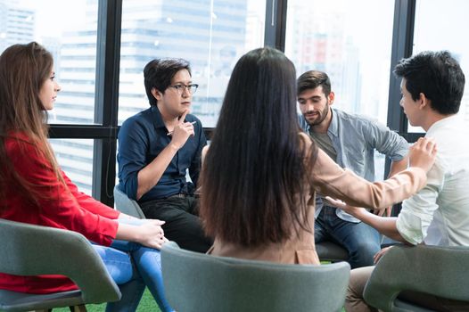 Psychotherapist inquiring about symptoms occurring within mind from patients with mental health problems in hospital. Group psychotherapy for support and helping worried man to change negative mindset