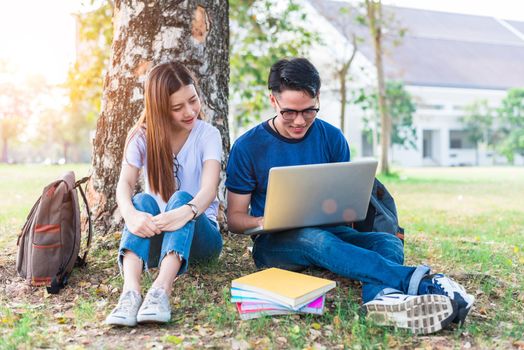 Two Asian young college people discussing about homework and final examination for testing with laptop. Education and Friendship concept. Happiness and Learning concept. Lovers and Friend theme.