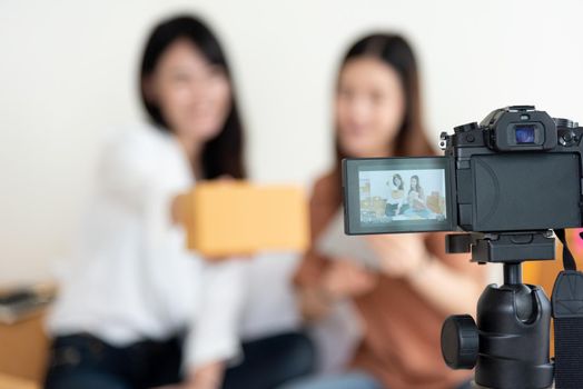 Closeup of digital video camera recording two girls presenting new product advertisement. Vlog and influencer concept. People part time job and occupation. Young teenagers using modern technology